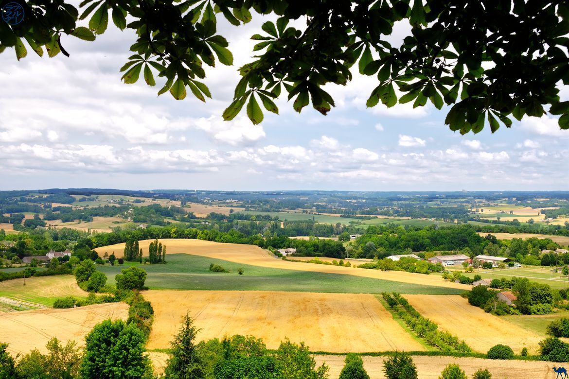 A rural landscape with fields, trees, and scattered buildings.