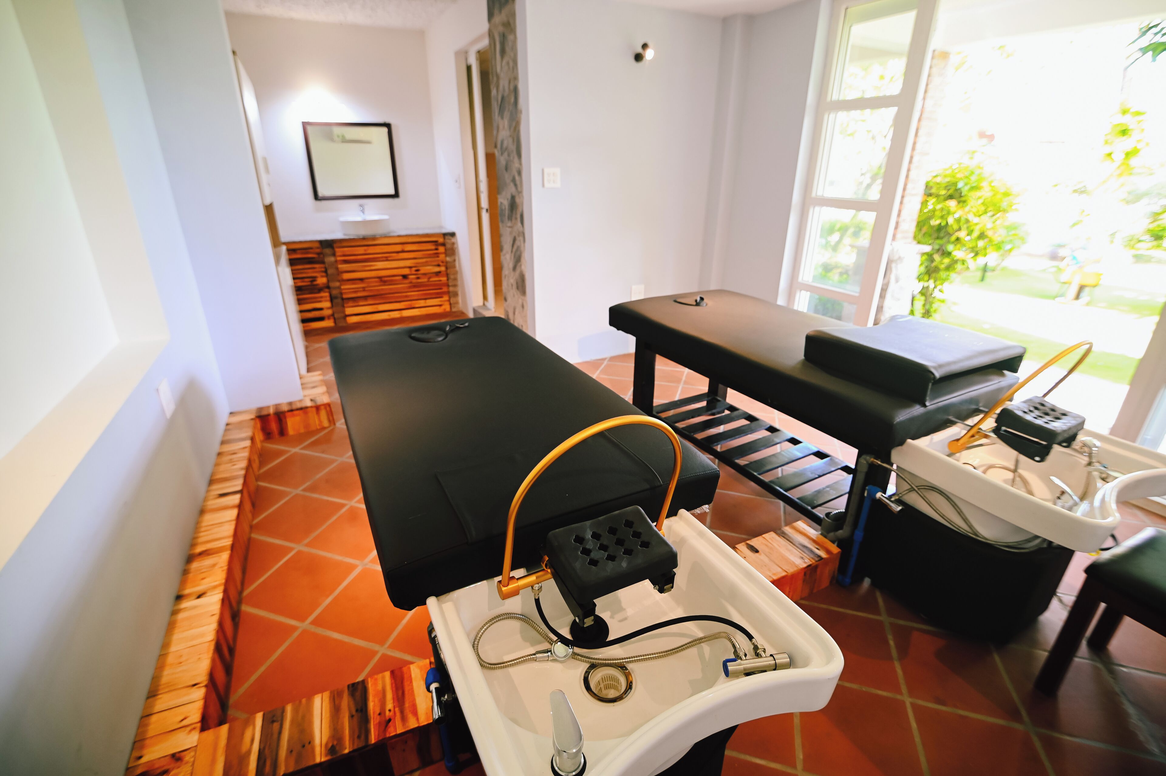 A medical examination room with a treatment table, a sink, and a chair.