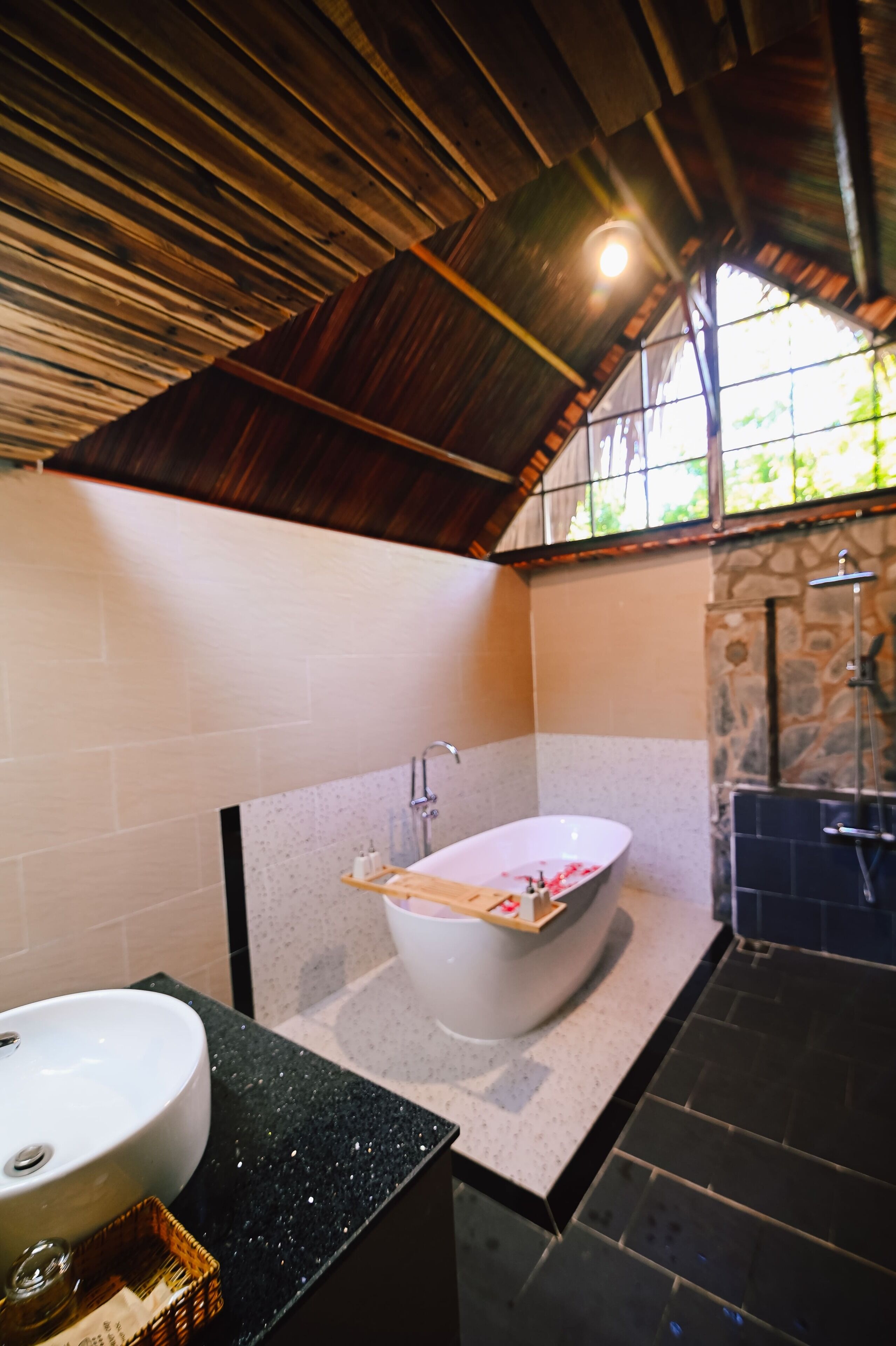 A bathroom with a freestanding bathtub, a sink, and a shower area.