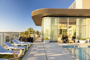 A rooftop pool area with lounge chairs, a pool, and a view of the cityscape. - Gym + Rooftop Deck + Pool + Spa | Little Italy Locale | Ancora by AvantStay (San Diego)