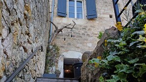 A stone staircase leading to a rustic building with a window and shutters. - Charming 13th-century house in a medieval village in the heart of the Golden Triangle (Cestayrols)