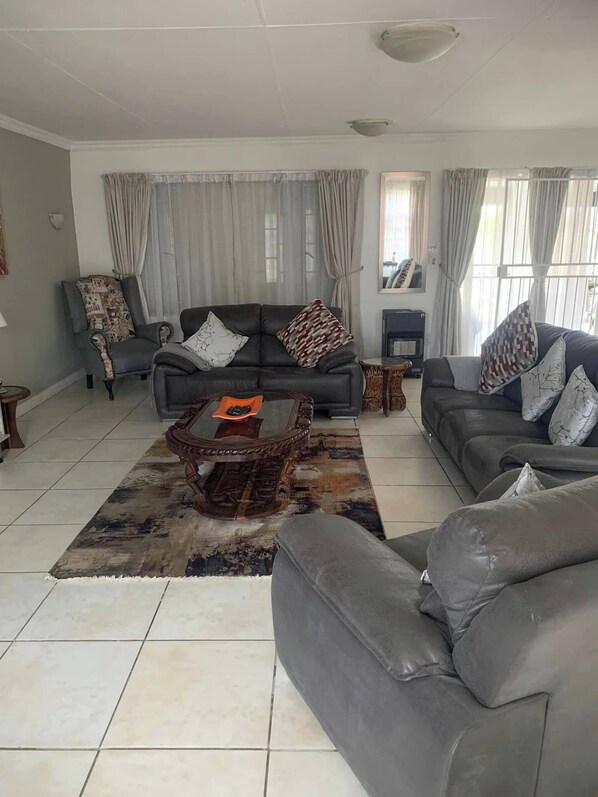 A living room with two sofas, a coffee table, a patterned rug, and a fireplace.