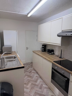 A compact kitchen with a sink, a toaster, a coffee maker, and an oven. - The Railway House, Colchester (Colchester)