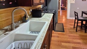 Una cucina con un lavello doppio, mobili in legno e un piano cottura.