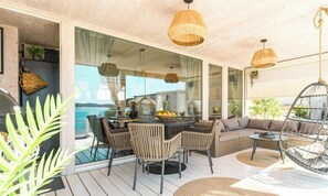 An open-plan living area with a dining table, chairs, a sofa, and a hanging chair. - Buqez - Villa 18 by Interhome (Pakoštane/Drage)