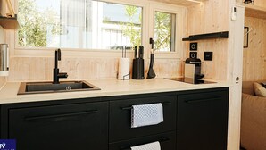 Una cucina moderna con un'ampia finestra, mobili neri e piano cottura integrato.