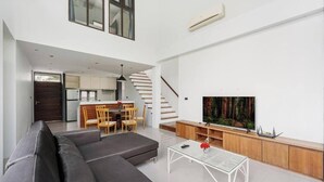 A modern living room with a sofa, a coffee table, a TV, and a staircase leading to a kitchen. - Ana's house in Lipa Noi (Lipa Noi)