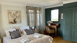 A bedroom with a bed, bedside table, chair, desk, and a window with curtains. - LA CADENIERE by Interhome (Carces)