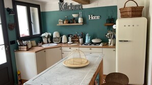 A compact kitchen with a central island, a refrigerator, and a window. - LA CADENIERE by Interhome (Carces)