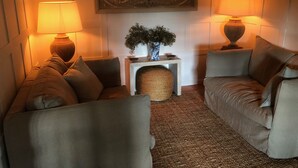 A cozy living room with two sofas, a small side table, a decorative vase, and two lamps. - Vacation home  by Interhome (Carces)