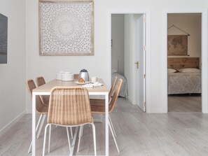 A dining area with a table, chairs, and a coffee maker. There is a bed in the adjacent room. - Apartamento en Puerta del Sol centro ciudad (Madrid)