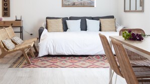 Ein Schlafzimmer mit einem Bett, einem Schreibtisch, einem Stuhl, einem Teppich und einem Bild an der Wand.