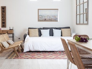 A bedroom with a bed, a desk, a chair, a rug, and a painting on the wall. - Apartamento en Puerta del Sol centro ciudad (Madrid)