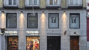 Un edificio con vetrine che mostrano le insegne 'TEZENIS underwear' e 'CALZEDONIA'.