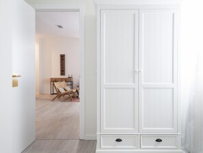 Ein weißer Kleiderschrank mit zwei Schubladen, ein Holzstuhl und ein an der Wand befestigtes Schild.