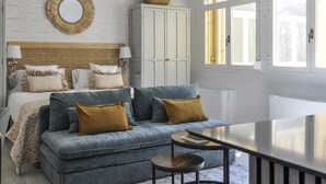 A bedroom with a bed, a sofa, a table, a wardrobe, and a window. - Fantastic Studio in Puerta del Sol (Madrid)