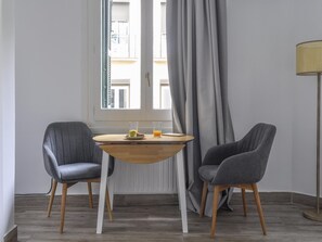 A room with a window, two chairs, a small table with a bowl and glasses, and a floor lamp. - Suite Estudio en Bravo Murillo (Madrid)