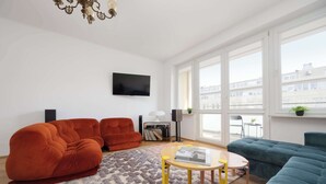A modern living room with a sofa, a coffee table, and a TV. - Stylish Apartment with Balcony | Center of Warsaw (Warszawa)
