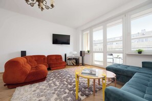 A modern living room with a sofa, a coffee table, and a TV. - Stylish Apartment with Balcony | Center of Warsaw (Warszawa)