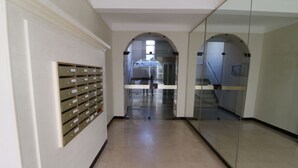 A hallway with a row of filing cabinets on the left and a glass wall on the right. - Apartment  by Interhome (Cannes)