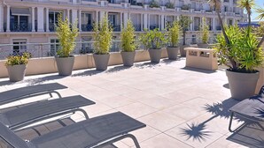 A rooftop terrace with outdoor seating and potted plants. - Apartment  by Interhome (Cannes)