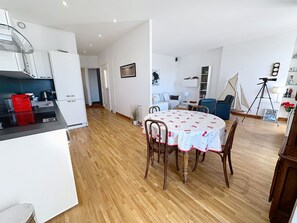 A modern kitchen with white cabinets, a red toaster, and a dining area with a round table and chairs. - 1 bedroom, fantastic view on the port. 269 by Interhome (Cannes)