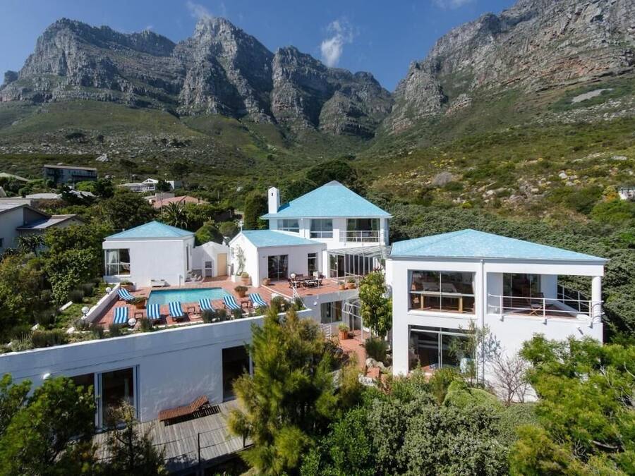 Eine moderne Villa mit Pool, mehreren Ebenen und einem Bergpanorama.