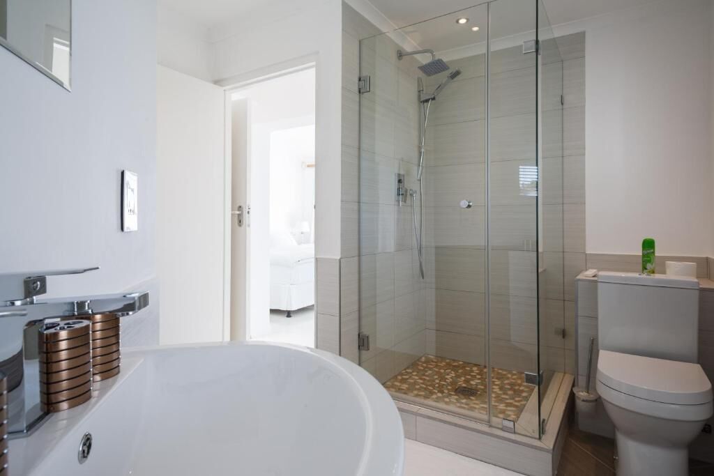 A modern bathroom with a freestanding bathtub, a glass-enclosed shower, and a toilet.