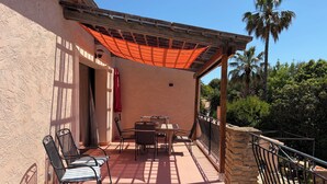 A patio with a table and chairs, a wooden pergola, and a stone wall. - 90m2 apartment (1st floor) in Port d'Alon, 4 persons, dogs welcome. (Saint-Cyr-sur-Mer)