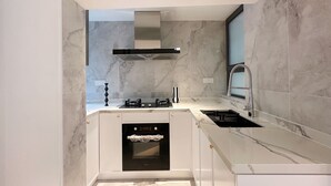 A modern kitchen with a built-in oven, stainless steel appliances, and a marble backsplash. - Spacious master bedroom equipped with a private walk-in closet near Yuyuan (Shanghai)