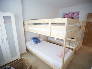 A bunk bed room with a wardrobe, a painting, and a wicker basket. - VILLA 25 by Interhome (Mutxamel)