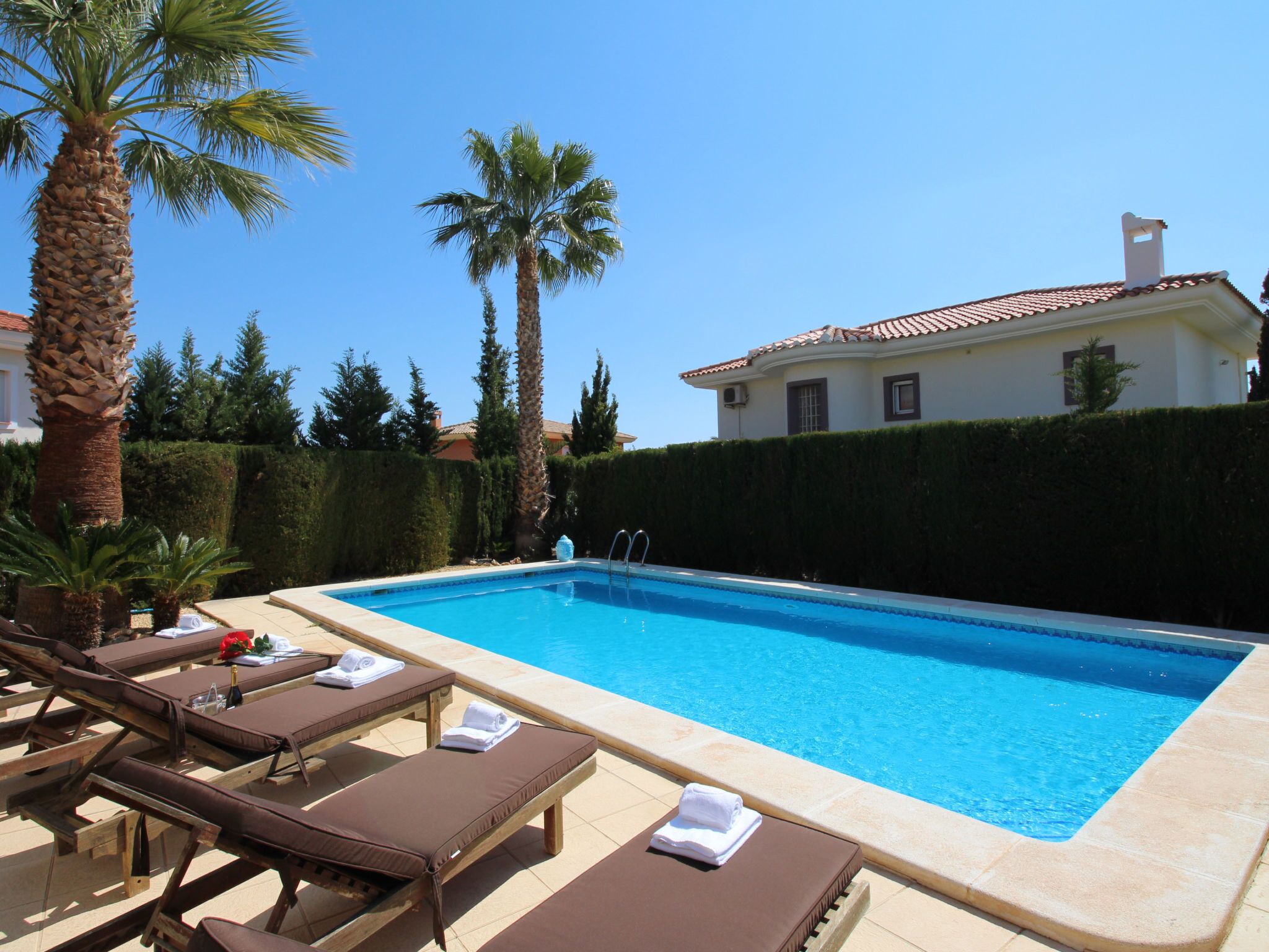 A swimming pool with lounge chairs and a building in the background.