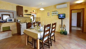 A compact kitchen with a dining area, a television, and a microwave. - Lovely Ground-floor Flat With Shared Pool in Tar (Tar-Vabriga)