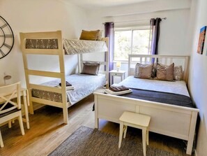 A room with bunk beds, a desk, and a window with curtains. - Apartment  by Interhome (Albufeira)