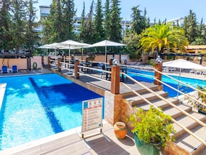 A pool area with multiple levels, umbrellas, and lounge chairs. - Apartment  by Interhome (Albufeira)