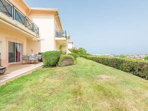 A residential property with a well-maintained lawn, outdoor seating area, and a view of the cityscape. - Apartment  by Interhome (Lagos)