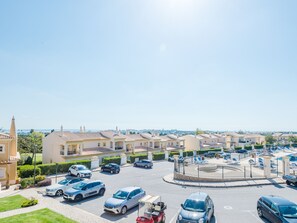 Ein Wohngebiet mit Kreisverkehr, parkenden Autos und Häusern mit ähnlicher Architektur.