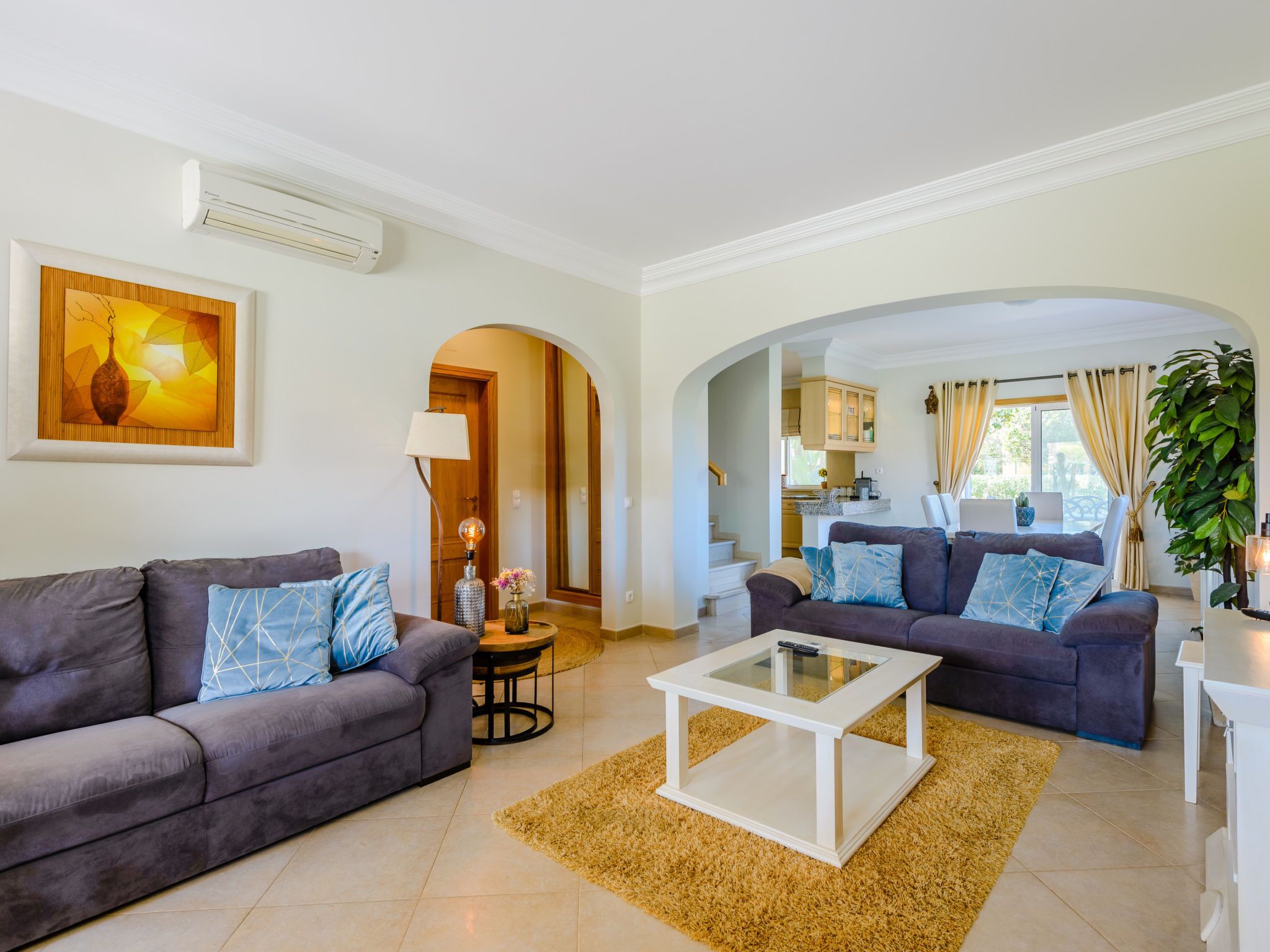 A modern living room with two sofas, a coffee table, and a painting on the wall.