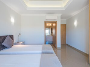 Ett hotellrum med en stor säng, en sänglampa och utsikt över badrummet.