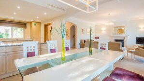 Ein modernes Wohnzimmer mit einem Glastisch, Sitzgelegenheiten und einem Kamin.