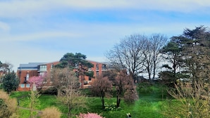 A park with a clock garden, a brick building, and trees. - ⭐ Luxury 5-Star Apartment with Panoramic Pannett Park Views & Parking (Whitby)