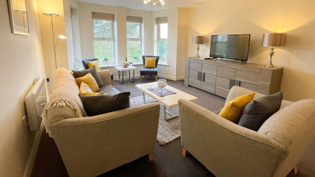 A living room with two sofas, a coffee table, a TV, and a cabinet. - ⭐ Luxury 5-Star Apartment with Panoramic Pannett Park Views & Parking (Whitby)