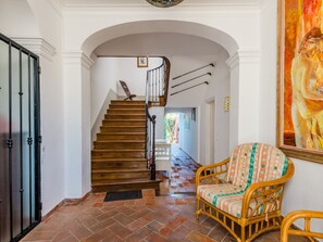 Eine Treppe mit Holzstufen und einem schwarzen Geländer, die zu einer oberen Etage führt.