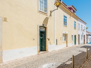 A street with cobblestone pavement and buildings with arched doorways and windows. - Apartment  by Interhome (Bensafrim)