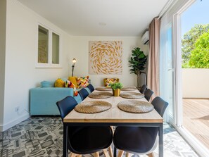 Un espace repas avec une longue table, des chaises et une plante.