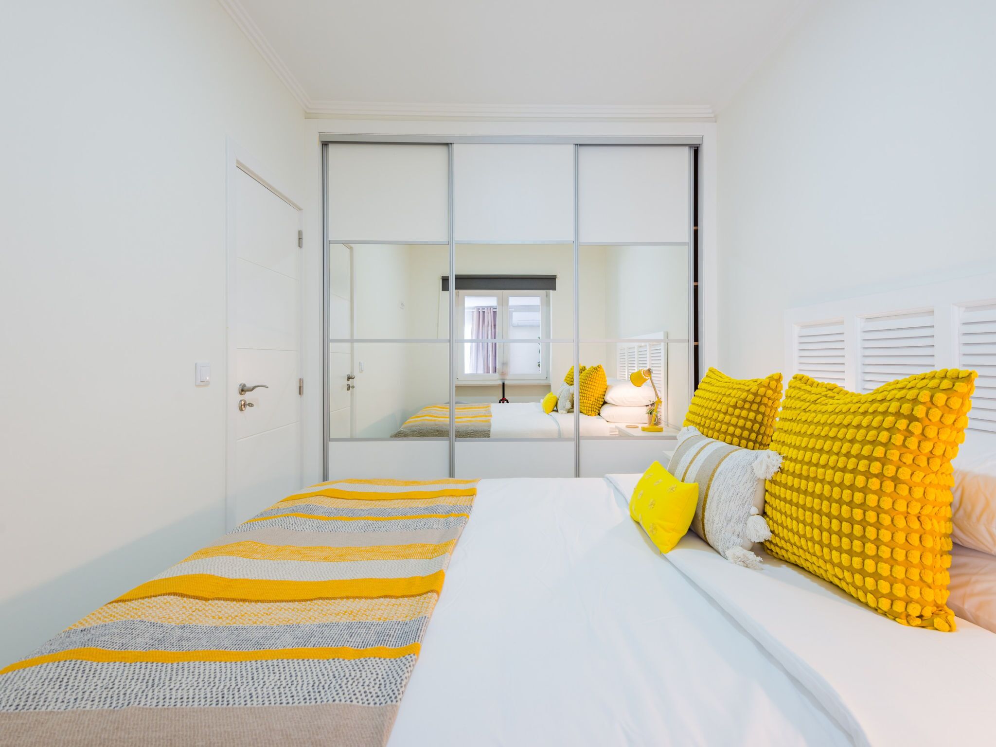 Une chambre à coucher avec un lit, une armoire et une fenêtre.