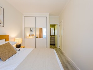 Ein Hotelzimmer mit Bett, Nachttischlampe und einer Tür zu einem Badezimmer.
