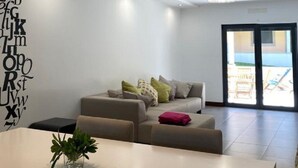 Een moderne woonkamer met een bank, een salontafel en een decoratieve wand met letters.