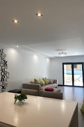 A modern living room with a sofa, a coffee table, and a decorative wall with letters. - Apartment  by Interhome (Alcobaça)