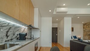 Eine moderne Küche mit Marmorarbeitsplatten, einer Kaffeemaschine und einem eingebauten Backofen.